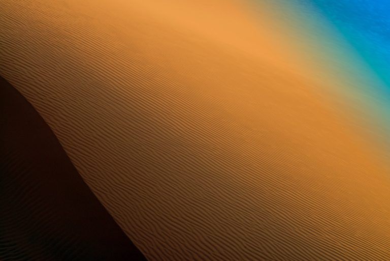 a desert landscape with sand dunes and blue sky